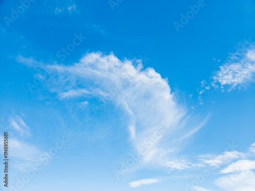 Expansive sky with soft, feathery clouds against clear blue