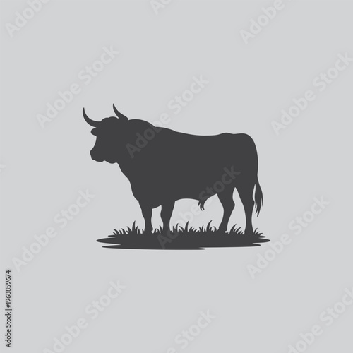 Profile silhouette of a bull standing in grass