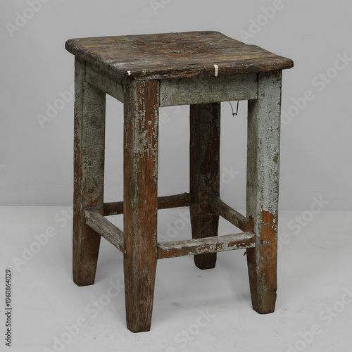 Weathered wooden stool exuding rustic charm, perfect for a cozy cabin setting or artisanal workshop atmosphere