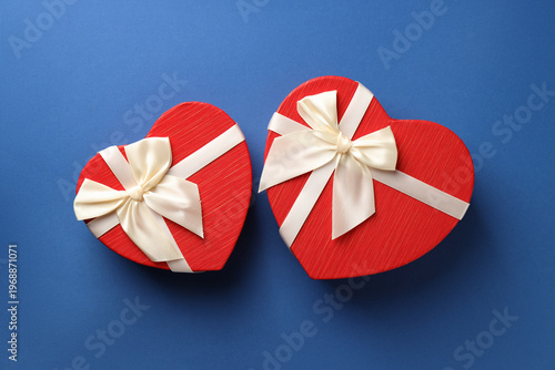 Beautiful heart shaped boxes on blue background, flat lay