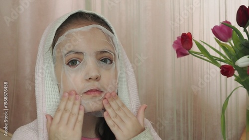 A beauty blogger, a girl dressed in a pink T-shirt, applies eye patches, films videos about her daily skincare routine, and reviews cosmetic products on social media. She films the videos on her phone