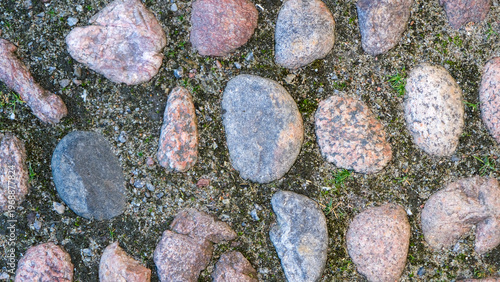 Top view of rustic cobblestone pavement with natural stones.