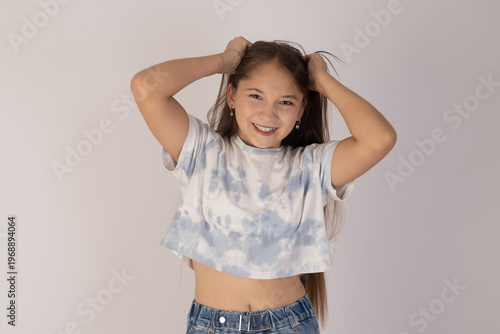 Young girl fixing her hair with both hands