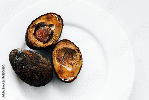 Rotten avocados isolated on white background, food spoilage concept