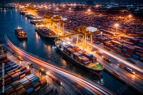 Night aerial of container terminal with cargo ships, cranes and dynamic light trails representing fast logistics, transport and supply chain efficiency.