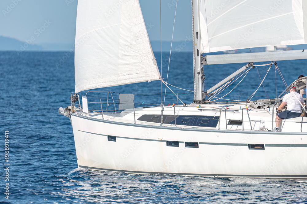 Fototapeta premium Sailboat cruising on open blue sea water