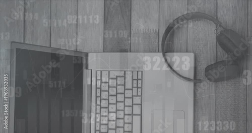 Animation of data processing and changing numbers over laptop and headphones on wooden surface