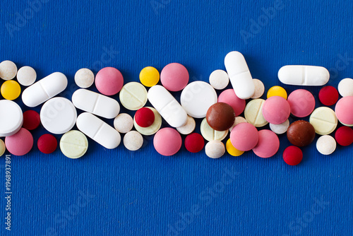 Pills and capsules lined up in the center of the background. Close-up. Photo with space for text