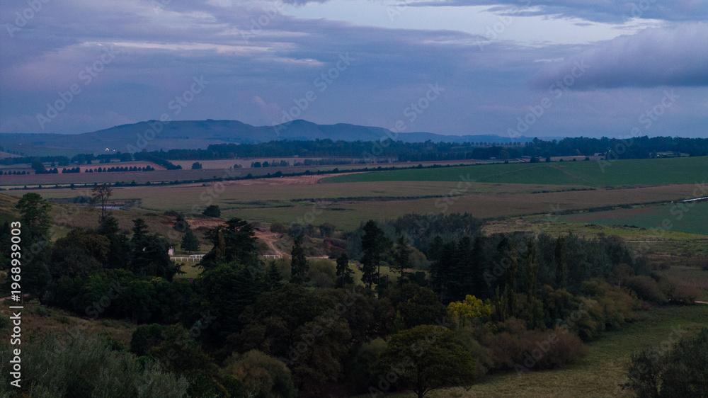 Naklejka premium Dramatic African Landscape with Colorful Sky and Rural Fields