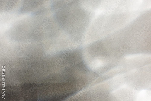 Photography Soft light caustics and shimmering water reflections create an abstract, dreamlike pattern on a white textured surface for minimalist design, background or overlay