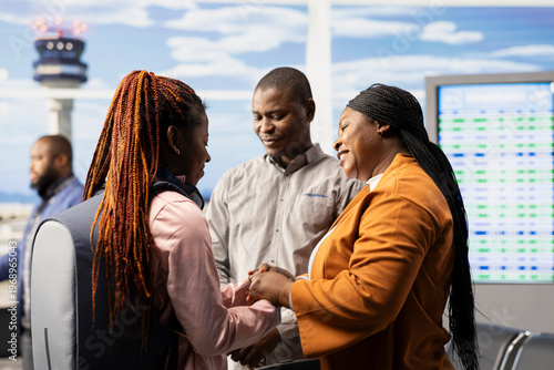 Cuadro en lienzo Sad mother and father saying farewell to their teenage daughter at airport, offering guidance before boarding airplane alone