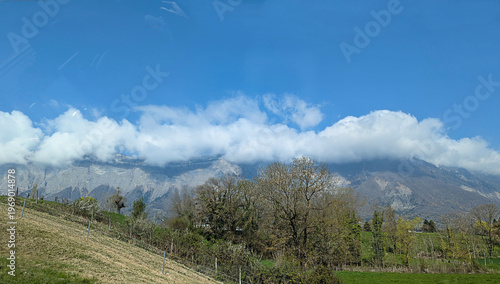 Picturesque Mountain Landscape with Clouds and Lush Green Fields, a Serene Outdoor Scene