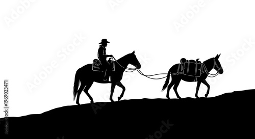 A cowboy rides horse pulling another horse up a hill in profile.