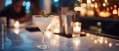 A cocktail glass on a bar table with a blurred background ambiance.