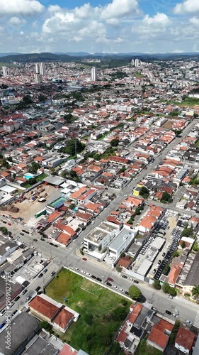 Vista aérea vertical da cidade de Mogi das Cruzes no Alto Tietê mostrando área urbana densa, ruas, casas e infraestrutura em destaque no cenário metropolitano paulista