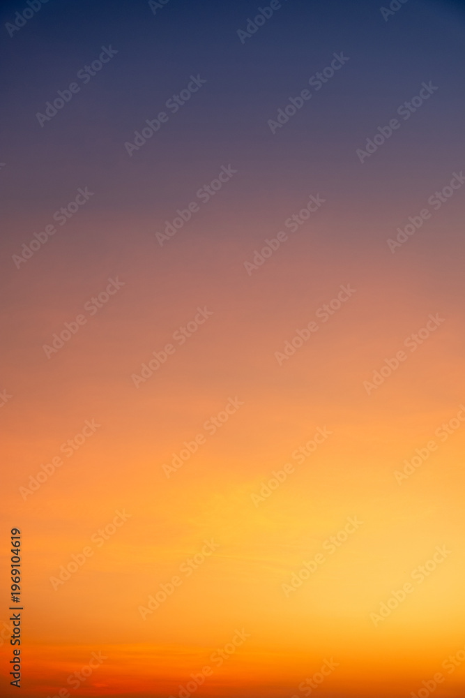 Fototapeta premium Sunset or sunrise sky with a vibrant gradient of orange, gold, and soft blue. Clear atmosphere with wispy clouds. Peaceful, natural light background. hope, freedom, new day and inspirational Concepts