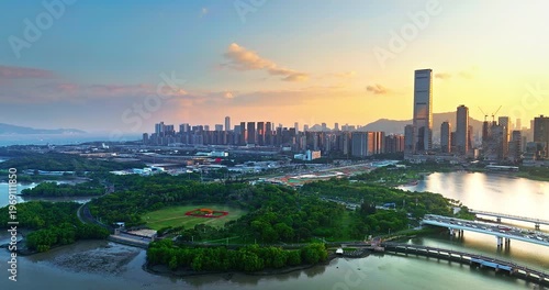 Aerial view of Shenzhen city skyline with modern skyscrapers and lush urban park at sunset, China. Financial district urban landscape.