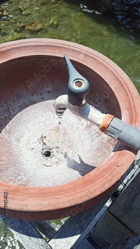 Wallpaper Mural A simple handwashing station using a clay jar, offering a traditional and natural way to maintain hygiene with an earthy and rustic aesthetic. Torontodigital.ca