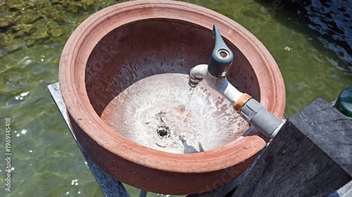 Wallpaper Mural A simple handwashing station using a clay jar, offering a traditional and natural way to maintain hygiene with an earthy and rustic aesthetic. Torontodigital.ca