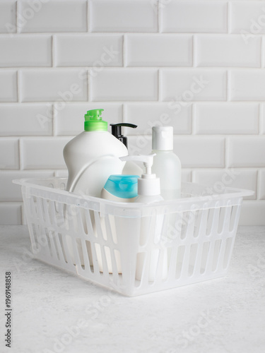 cleaning and cosmetic products in plastic basket on white background hygiene and care concept