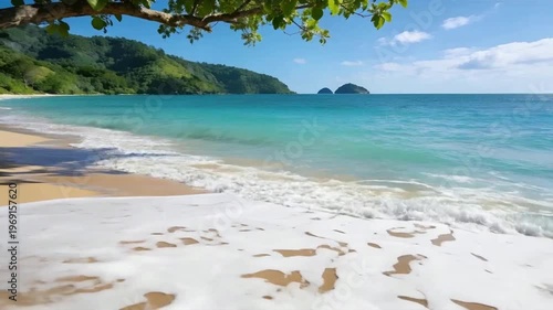 Serene Tropical Beach With Turquoise Waves Rolling Onto Golden Sand And Lush Island Background Under Clear Blue Sky
