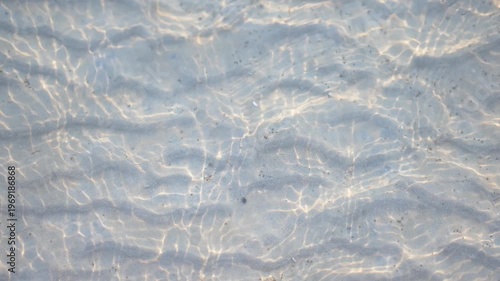 Clear water rippling over a sandy bottom