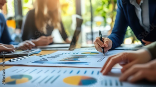 A group of business professionals analyzing data and graphs in a meeting room with a blurred background