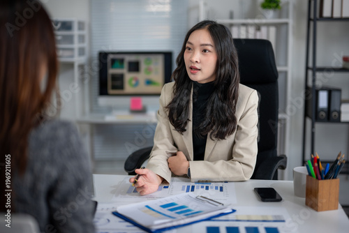 Photos Businesswoman discussing financial data with client in office
