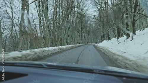 Driving through a snowy winter forest road