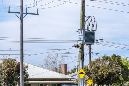 Canvas Print Electricity distribution transformer mounted on a utility pole in a suburban neighborhood in Australia, with overhead power lines and residential houses nearby
