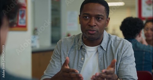 Man gesturing while talking in interior setting