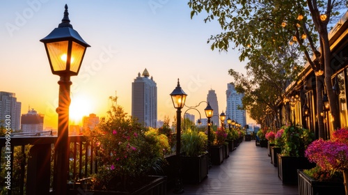 Beautiful sunset view from a balcony adorned with flowers and lamps overlooking city skyscrapers