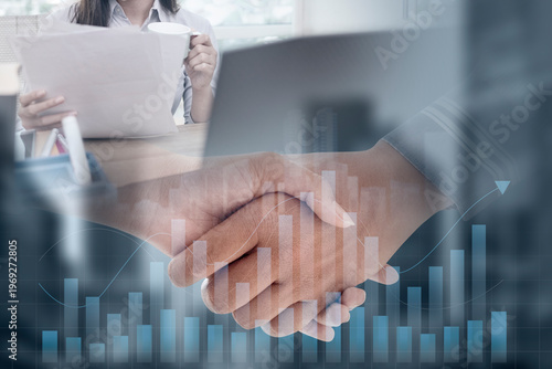 Two business professionals shaking hands, superimposed with a rising financial bar graph and a background scene of office work, symbolizing successful partnership and growth