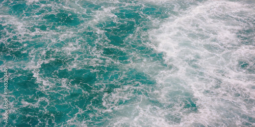 Abstract a close-up of dynamic ocean waves, with frothy water, capturing the raw power and natural beauty of the sea.