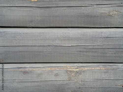 Weathered gray wooden planks background with natural texture and visible grain. Rustic aged wood surface with cracks and imperfections, ideal for vintage design, backgrounds, or copy space