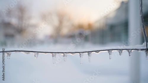 Slow camera movement along ice-covered wire close-up with blurred background