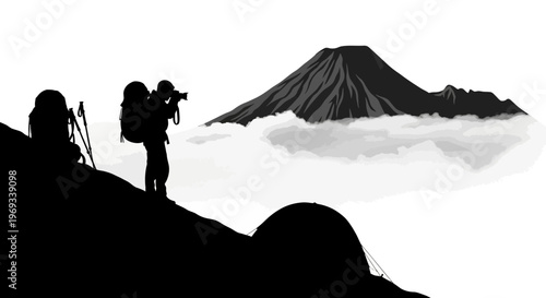 Silhouette of a hiker photographing a mountain peak above the clouds