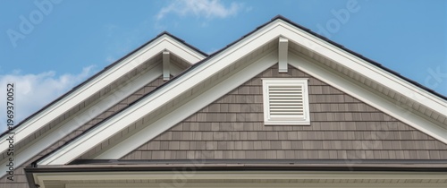 Vinyl sided gable roof with white fascia and soffit featuring corbel and bracket details framed by sky backdrop