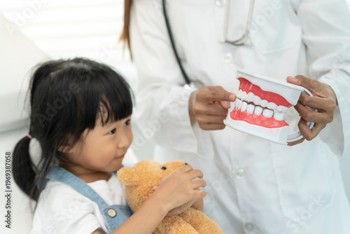 Foto Dentist or dentist treating and advice little girl teeth, Child receiving treatm