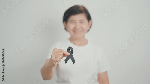 Elderly with Black ribbon for May Melanoma and skin cancer Awareness month, October Vaccine injury awareness month, Mourning Remembrance, March Sleep awareness week, Gang Prevention and Anti Violence