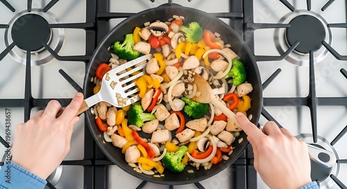 Stir-frying colorful vegetables and chicken on stovetop burner for healthy meal