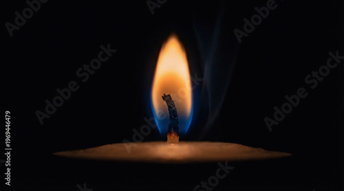 Macro candle flame on black background, burning wick with orange and blue glow, spiritual and peaceful atmosphere