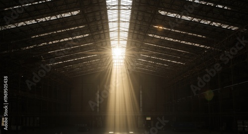 Sunlit warehouse interior with bright beams of sunlight through the roof