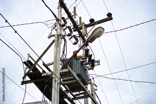 Overhead electrical transformer on utility pole, trafo dengan kabel listrik yang tidak rapi