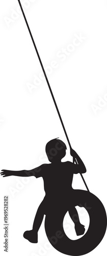 Silhouette of a child swinging on a tire swing suspended from a rope.