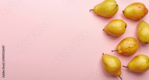 Top view photography of fresh pears displayed on a pink backdrop with a lively fruit arrangement and copy space