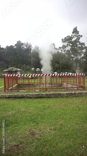 Wallpaper Mural Geothermal area with natural steam rising from the ground, surrounded by a safety fence in a green mountainous landscape. Torontodigital.ca