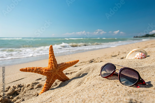 Starfish and sunglasses on a sandy beach with ocean waves in the background