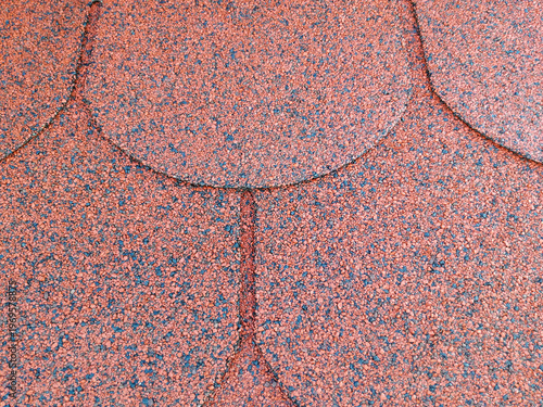 Red bitumen shingles (flexible shingles) used as roofing. Close-up
