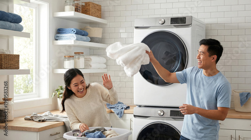 Young Asian Couple Playfully Doing Laundry in Modern Laundry Room, Fun Home Chores Moment
